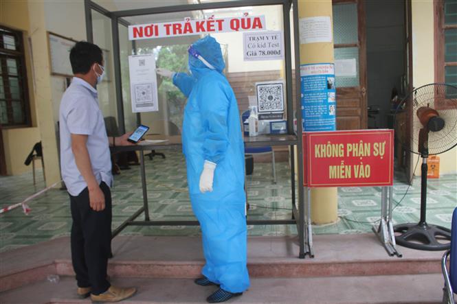 Nhân viên y tế phường Ninh Khánh, thành phố Ninh Bình lấy mẫu và hướng dẫn người bệnh khai báo y tế. Ảnh: Hải Yến/TTXVN.