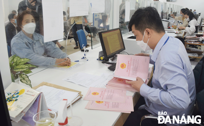 Cán bộ Chi nhánh Văn phòng Đăng ký đất đai tại UBND huyện Hòa Vang giải quyết các hồ sơ về đất đai cho người dân. Ảnh: HOÀNG HIỆP