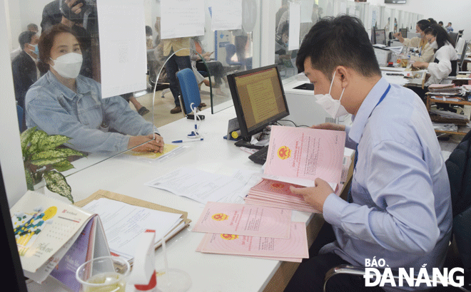 A staff at the Hoa vang District Branch of the Da Nang Land Registration Office handling land-related dossiers for local people. Photo: HOANG HIEP