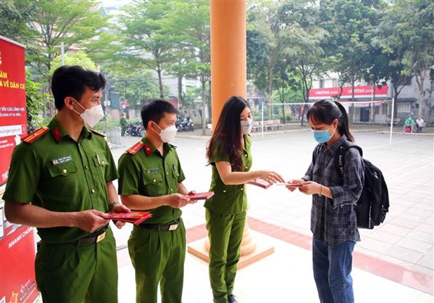 Cán bộ, chiến sỹ Cục Cảnh sát Quản lý hành chính và trật tự xã hội (Bộ Công an) hướng dẫn người dân đến đăng ký tài khoản định danh điện tử. (Ảnh: Phạm Kiên/TTXVN)