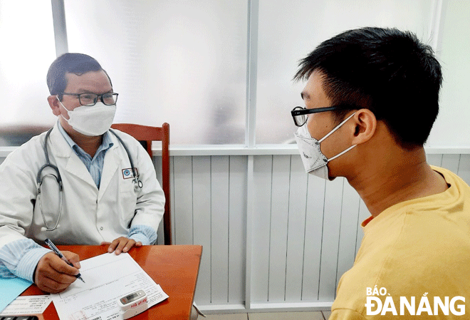 Bác sĩ Bệnh viện Đà Nẵng (bên trái) khám, tư vấn điều trị các triệu chứng cho bệnh nhân hậu Covid-19. Ảnh: PHAN CHUNG
