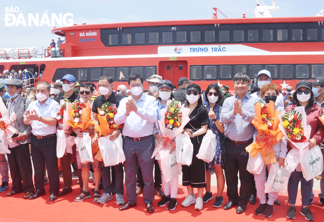 Leaders of Da Nang and Quang Ngai Province presented flowers to the first 20 passengers setting foot in the Ly Son Island from Trung Trac Ship. Photo: THANH LAN - VAN HOANG