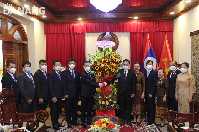 Secretary Quang (6th, left) and some of the city's leaders presenting flowers to congratulate staff of the Consulate General of Laos in Da Nang. Photo: L.P