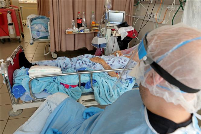 Nhân viên y tế điều trị cho bệnh nhân COVID-19 tại trung tâm y tế ở Ashkelon, Israel, ngày 22/2/2022. Ảnh: AFP/ TTXVN