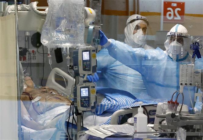 Nhân viên y tế điều trị cho bệnh nhân Covid-19 tại trung tâm y tế ở Ramat Gan, Israel. Ảnh: AFP/ TTXVN
