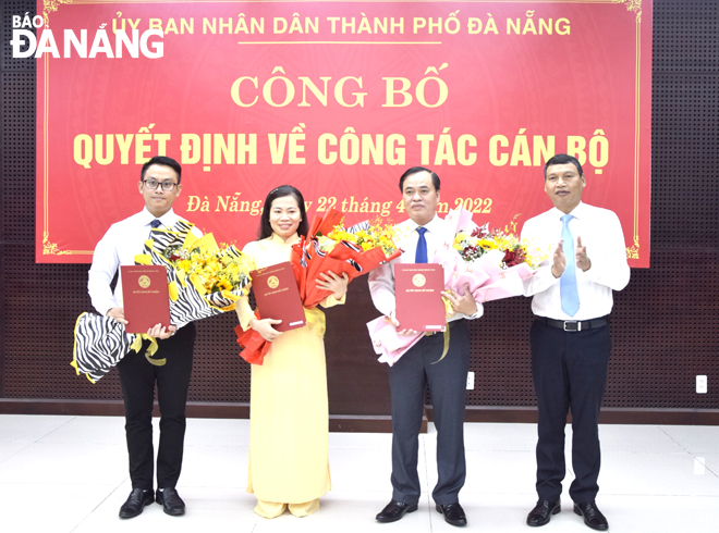 Phó Chủ tịch Thường trực UBND thành phố Hồ Kỳ Minh (ngoài cùng, bên phải) trao quyết định, tặng hoa chúc mừng tại buổi công bố. Ảnh: T. HUY