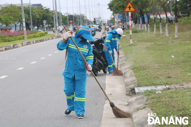 Workers of the central branch of URENCO clean up on Nam Ky Khoi Nghia street, Hoa Quy Ward, Ngu Hanh Son District. Photo: VAN HOANG