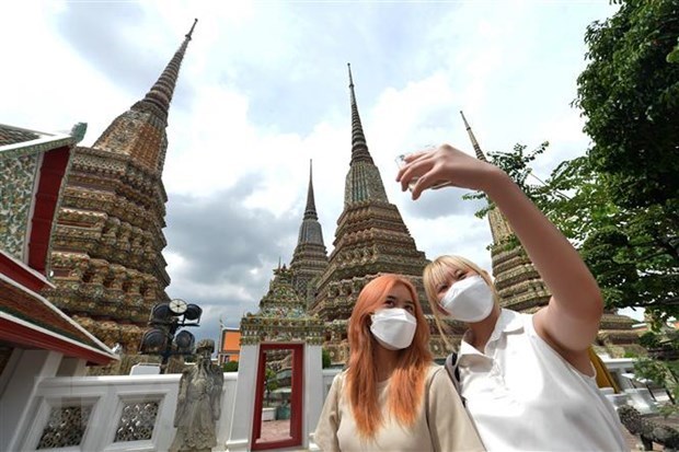 Tourists take a photo at a pagoda in Bangkok, Thailand. (Photo: Xinhua/VNA)