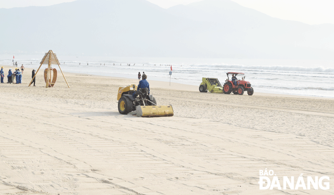 The Da Nang Urban Environment JSC mobilizes motor vehicles to sieve sand on the beach in the East Sea Park area in Son Tra District to ensure the safety of tourists. Photo: HOANG HIEP