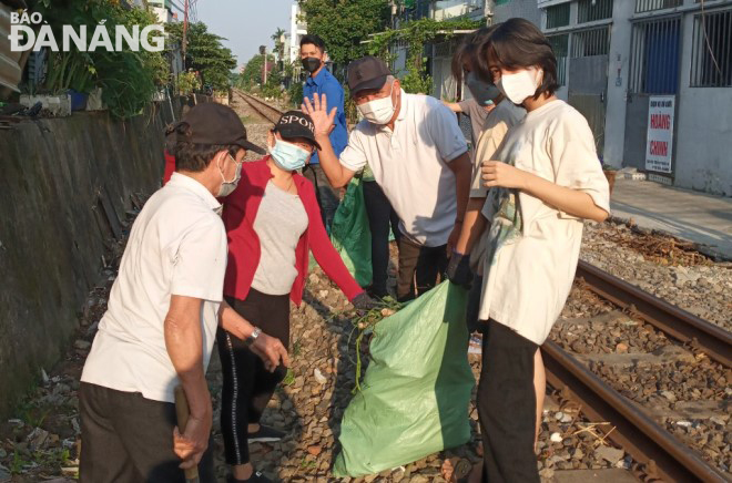 Veterans and Youth Union members of Chinh Gian Ward, Thanh Khe District collect garbage along a rail track.