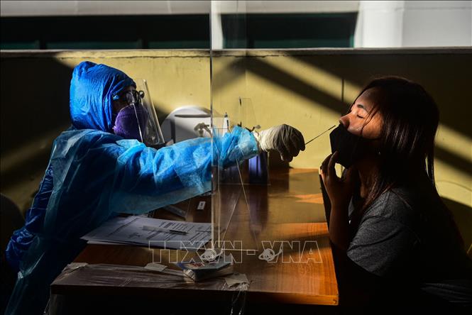 Nhân viên y tế lấy mẫu xét nghiệm Covid-19 tại Quezon, Philippines. Ảnh: AFP/TTXVN