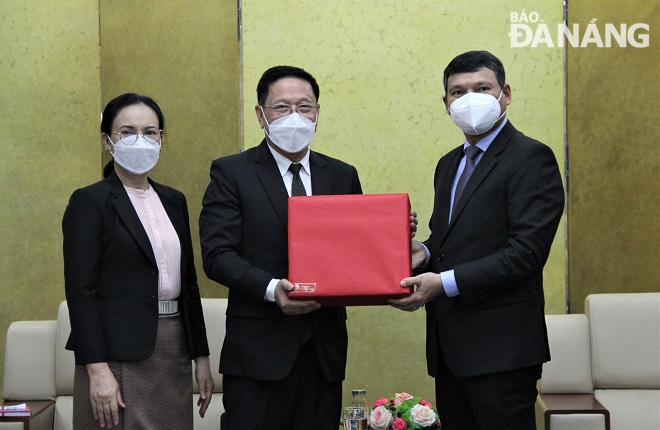 Phó Chủ tịch Thường trực UBND thành phố Hồ Kỳ Minh () tặng quà lưu niệm cho Tổng Lãnh sự Lào tại Đà Nẵng Viengxay Phommachanh và phu nhân. Ảnh: L.P