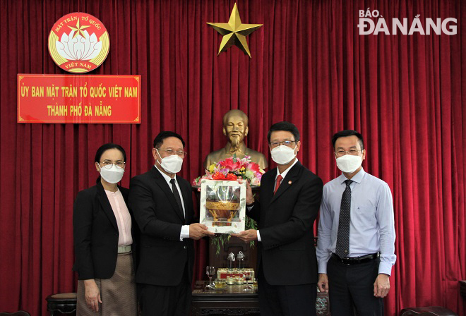 Chairman of the Da Nang Committee of the Viet Nam Fatherland Front Ngo Xuan Thang (second from right) presenting a souvenir gift to the Lao guest. Photo: L.P