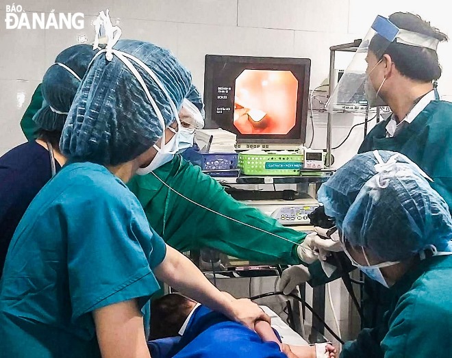 Surgeons from the Da Nang Family General Hospital are seen performing an endoscopy to remove a stone sample attached to a ring from the stomach of the 16-month-old boy.