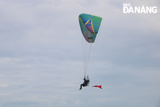 A motorised paragliding performance at the opening ceremony of the Da Nang Sea Sports Festival - Da Nang Color Race 2022 at the Man Thai Beach, Son Tra District. Photo: VAN HOANG