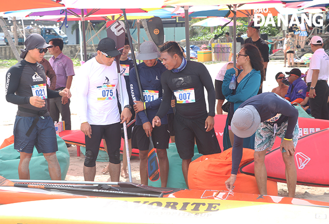 Athletes in the SUP 1000m men's race are seen checking their SUPs before the start of the race. Photo: VAN HOANG