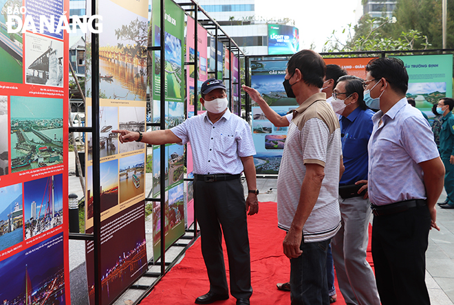 Visitors are seen admiring photos on display at the exhibition ‘Da Nang – the city of bridges’ in Nam Duong Ward. Photo: Xuan Dung