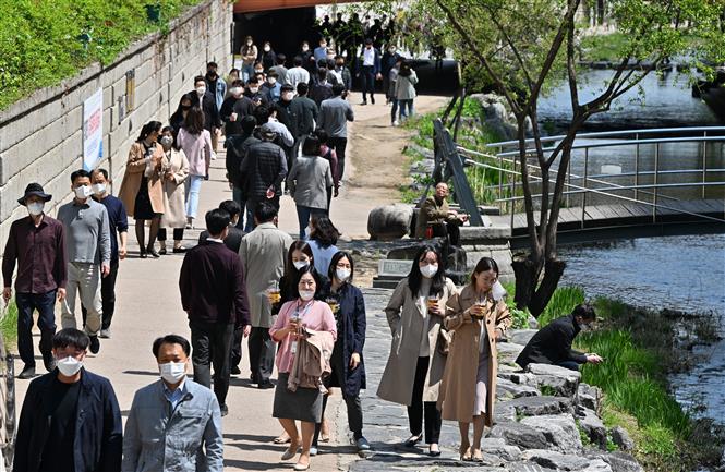Người dân đeo khẩu trang phòng dịch Covid-19 tại Seoul, Hàn Quốc ngày 15-4-2022. Ảnh: AFP/TTXVN