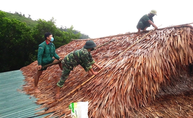 Border Guards in the central province of Quảng Bình help local residents strengthen their house before storm weather last year. — VNA/VNS Photo