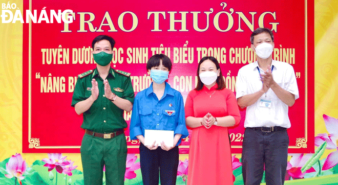 Em Nguyễn Đoan Kỳ (thứ hai, trái sang) nhận học bổng do Bộ đội Biên phòng thành phố phối hợp quận Thanh Khê trao tặng.  Ảnh: PHƯƠNG MINH	