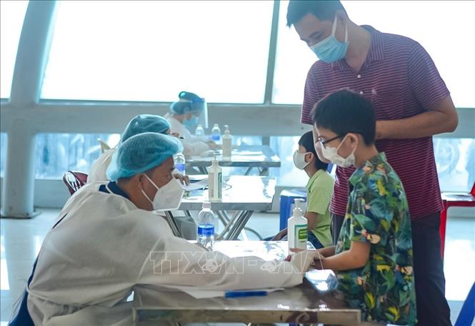 Nhân viên y tế khám sàng lọc trước tiêm cho các em học sinh tại thành phố Đà Nẵng. Ảnh: Văn Dũng/TTXVN