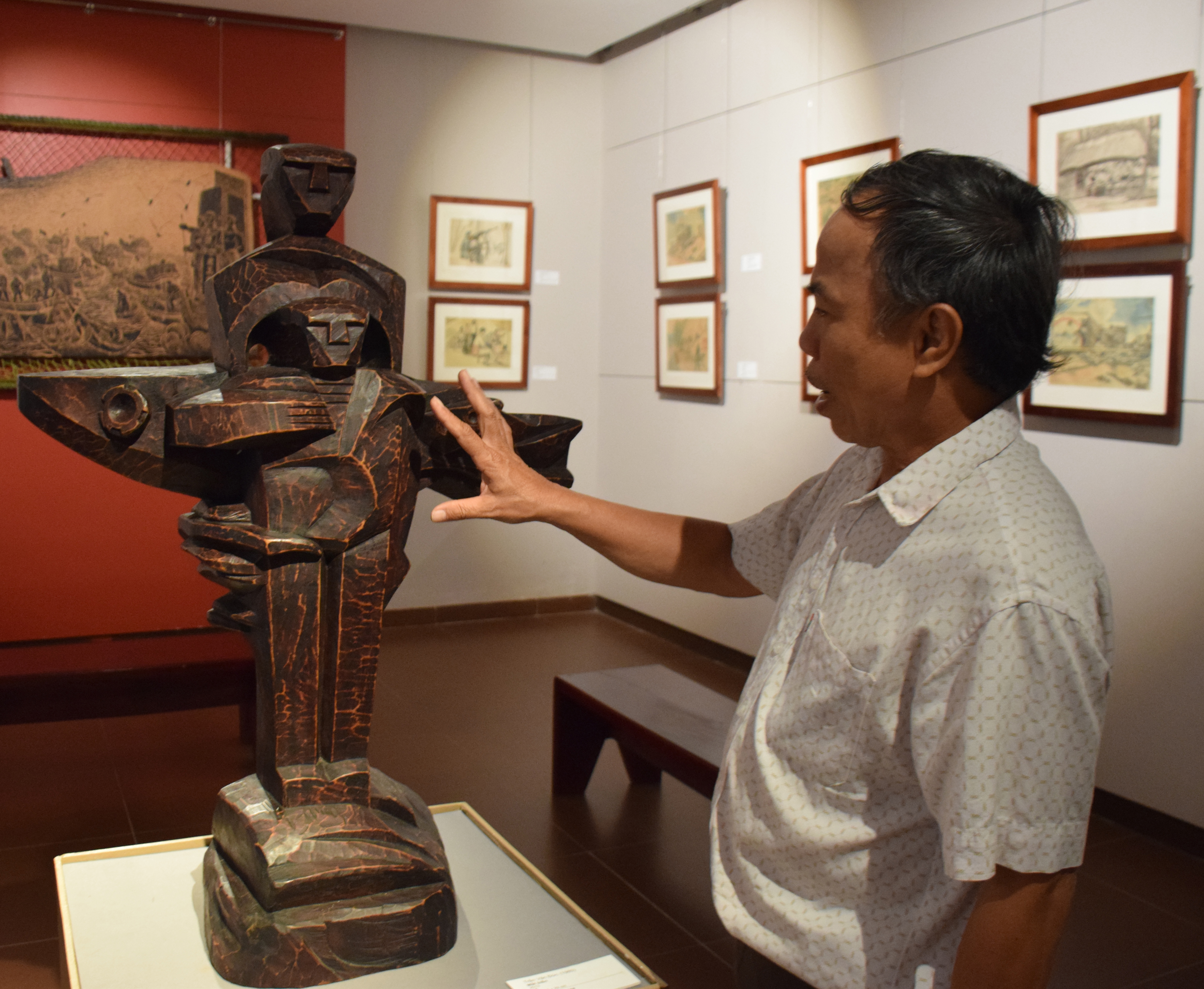 Painter Nguyen Trung Ky introducing a war-themed sculpture on display at the Da Nang Fine Arts Museum. Photo: D.H.L