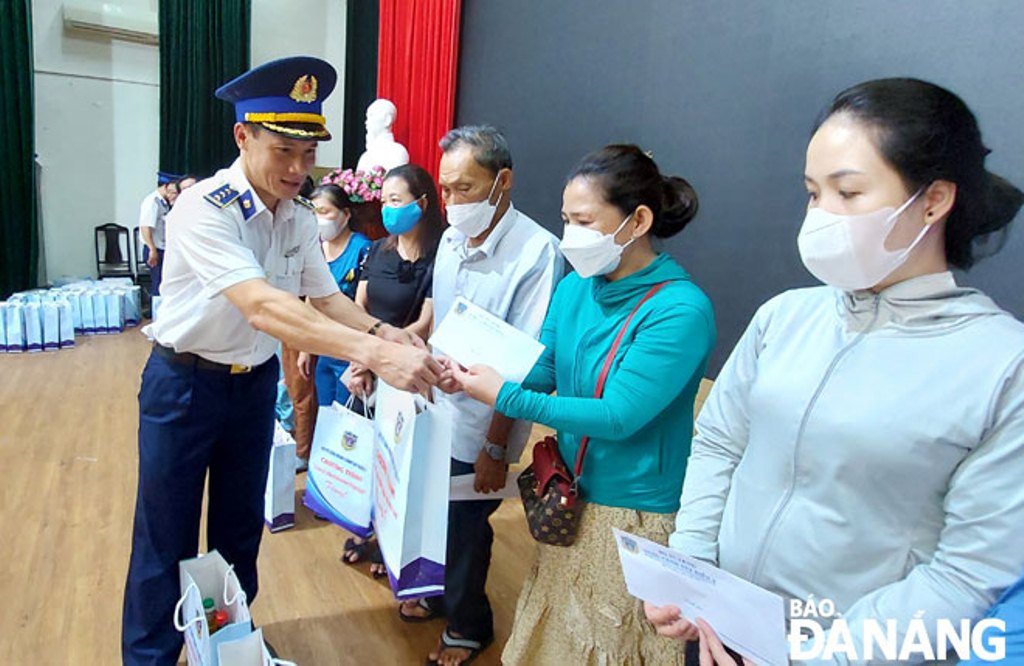 Đại diện Ban Dân vận Thành ủy và Bộ Tư lệnh Vùng Cảnh sát biển 2 trao quà cho ngư dân. Ảnh: TRỌNG HÙNG