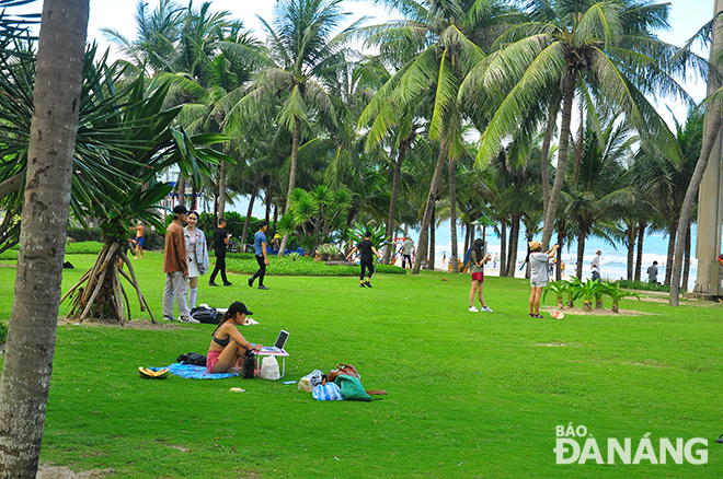 Tourists spread canvas over lawns for working and relaxing.