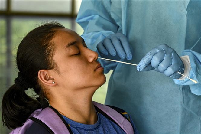 Nhân viên y tế lấy mẫu xét nghiệm COVID-19 cho người dân tại New Delhi, Ấn Độ ngày 5/5/2022. Ảnh: AFP/TTXVN