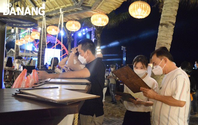 Visitors are seen choosing nighttime tourism services at the My An Beach, Ngu Hanh Son District. Photo: THU HA