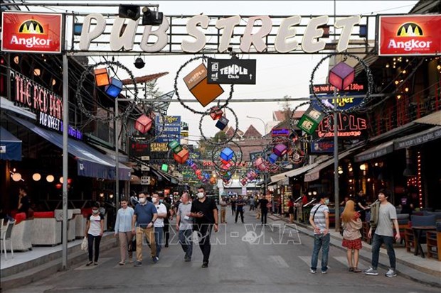 Tourists wear facemasks as they walk along Pub Street in Cambodia's Siem Reap province. (Photo: AFP/VNA)