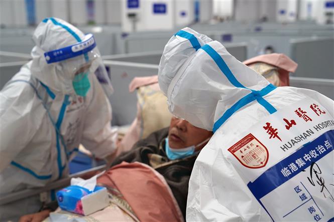 Nhân viên y tế điều trị cho bệnh nhân Covid-19 tại bệnh viện dã chiến ở Thượng Hải, Trung Quốc, ngày 23-4-2022. Ảnh: THX/ TTXVN