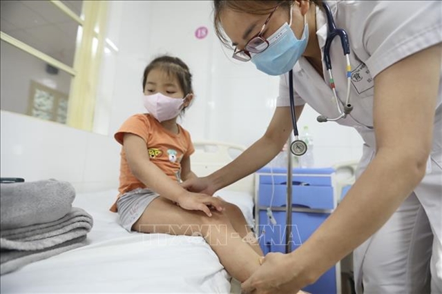 A doctor gives a health check-up for a child at Thanh Nhàn Hospital in Hà Nội. Hospitals are required to closely monitor the acute hepatitis of unknown origin and report unusual cases. VNA/VNS Photo