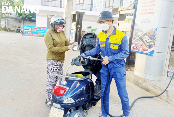 Petrol and oil price hikes have been affecting transportation activities. A motorcyclist has her vehicle re-filled at the filling station on February 3 Street, Hai Chau District. Photo: KIM NGAN