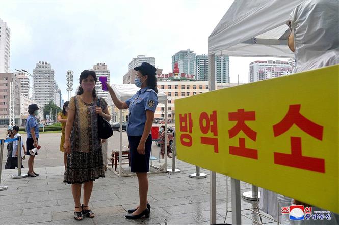 Kiểm tra thân nhiệt nhằm ngăn chặn sự lây nhiễm của dịch COVID-19 tại một trường học ở Bình Nhưỡng, Triều Tiên. Ảnh: AFP/TTXVN