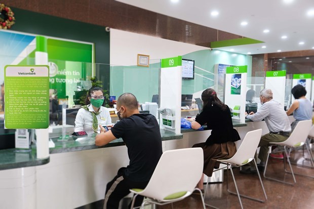 Customers conduct transactions at a branch of Vietcombank in Hanoi. (Photo: VNA)