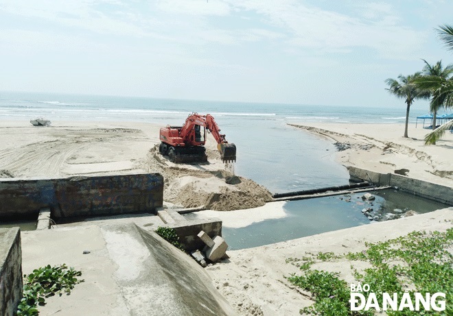 Da Nang Sewerage and Wastewater Treatment Company mobilising excavators to fill the creek with rainwater on the My Khe and My An beaches. 