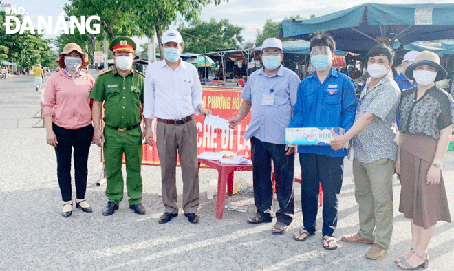 Ông Hoàng Cảnh Mẫn (thứ 4, bên phải sang), Phó Chủ tịch Ủy ban MTTQ Việt Nam phường Hòa Minh trao quà hỗ trợ lực lượng phòng, chống Covid-19 trên địa bàn phường. Ảnh: TRỌNG HÙNG