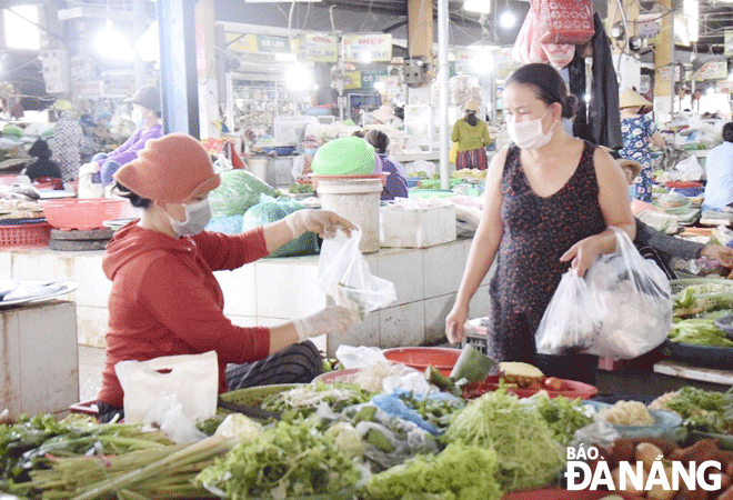  The price of essential items has increased, causing people to have to tighten their belts. Shoppers are seen at the Tuy Loan wet market. Photo: QUYNH TRANG
