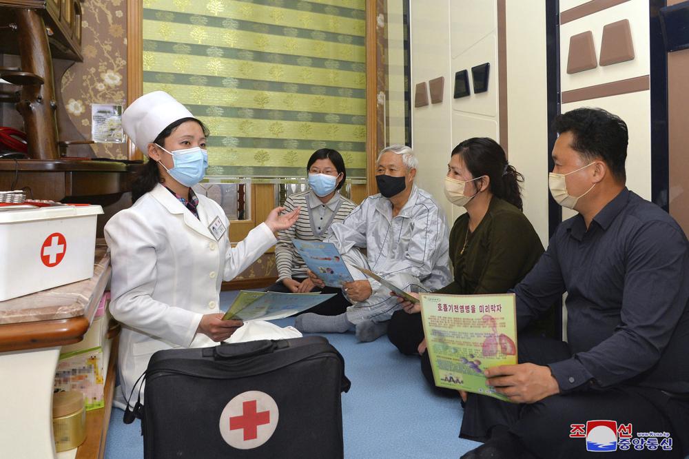 Nhân viên y tế hướng dẫn một gia đình ở thủ đô Bình Nhưỡng cách vệ sinh cá nhân để phòng, chống dịch. Ảnh: KCNA/AP	