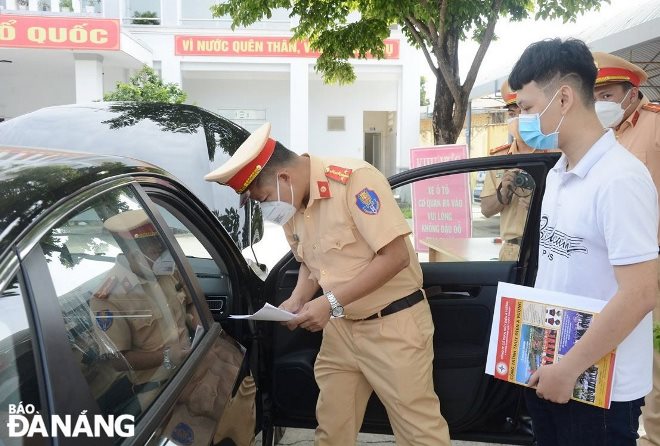 Cán bộ, chiến sĩ Công an huyện Hòa Vang kiểm tra số khung, số máy phương tiện ô-tô của người dân đến đăng ký  làm thủ tục. Ảnh: LÊ HÙNG