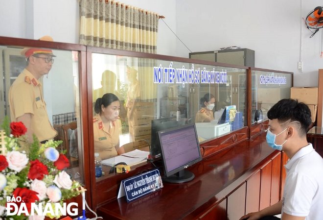 Cán bộ, chiến sĩ Công an huyện Hòa Vang tiếp nhận hồ sơ đăng ký xe ô-tô của người dân. Ảnh: LÊ HÙNG
