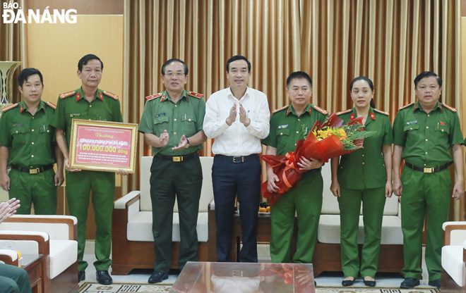 Chairman Chinh (middle) presenting VND 100 million to police officers who participated in investigating and breaking illegal drug trafficking by air from abroad into Da Nang. Photo: LE HUNG