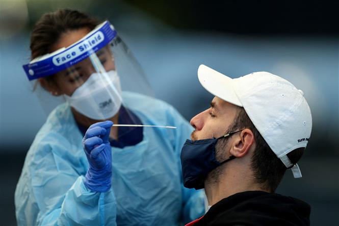 Nhân viên y tế lấy mẫu xét nghiệm COVID-19 tại Sydney, Australia. Ảnh: AFP/TTXVN