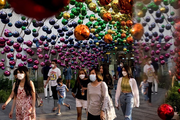Residents wearing face masks walk on streets in Bangkok, Thailand. (Photo: VNA)