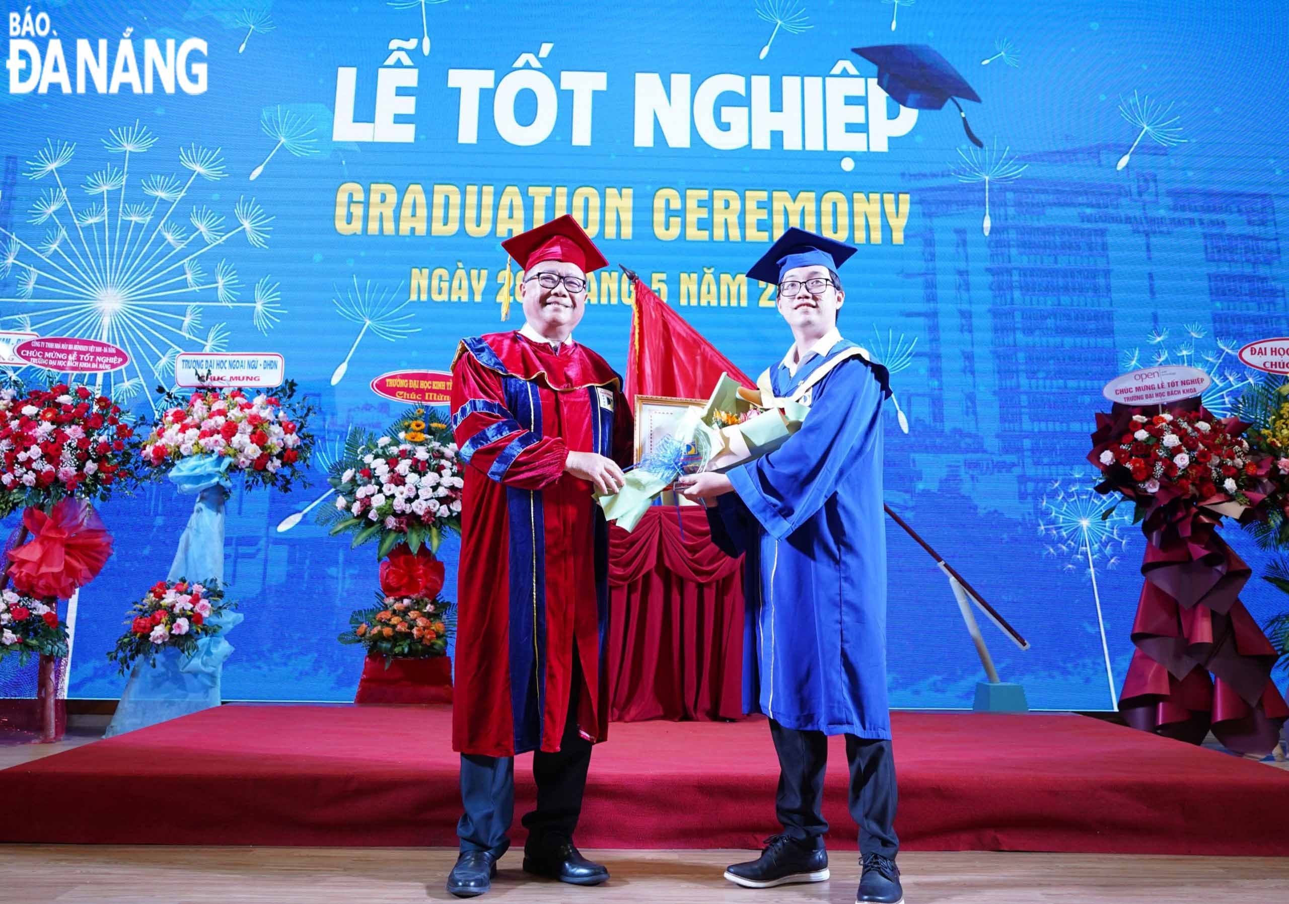 A student who achieves the title of valedictorian is honoured by the university’s leader. Photo: NGOC HA