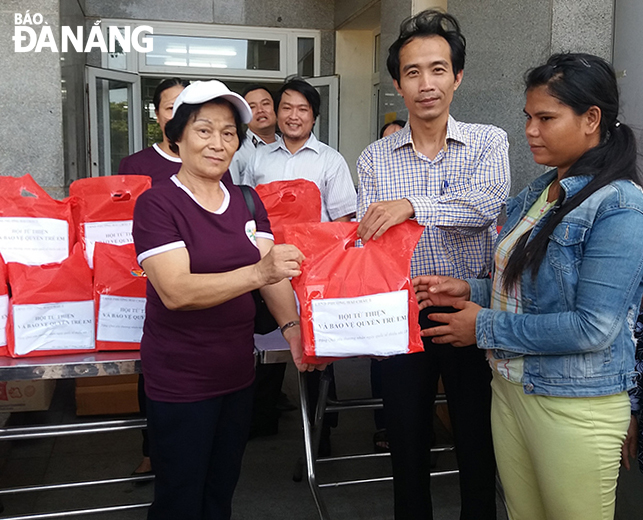 Bà Phạm Thị Mùi (bên trái) trao quà cho người khó khăn tại Bệnh viện Phụ sản - Nhi Đà Nẵng