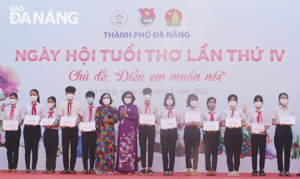 Phó Chủ tịch UBND thành phố Ngô Thị Kim Yến (thứ 7, trái sang) trao học bổng cho trẻ em có hoàn cảnh khó khăn. Ảnh: LÊ VĂN THƠM