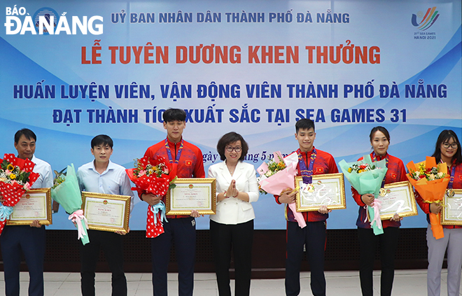 Phó Chủ tịch UBND thành phố Ngô Thị Kim Yến (giữa) tặng bằng khen chúc mừng các huấn luyện viên, vận động viên. Ảnh: XUÂN DŨNG