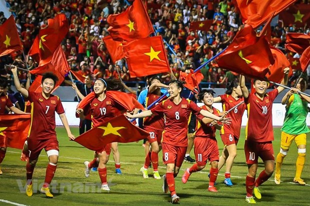 Đội tuyển nữ Việt Nam cầm quốc kỳ, chạy quanh sân vận động Cẩm Phả ăn mừng giành huy chương Vàng tại SEA Games 31 cùng với hơn 16.000 khán giả trên khán đài. (Ảnh: PV/Vietnam+)